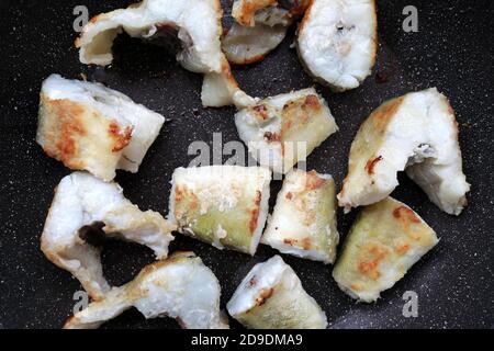 Pieces of fried navaga fish in pan Stock Photo