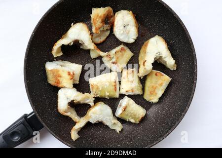 Pieces of fried navaga in a pan Stock Photo