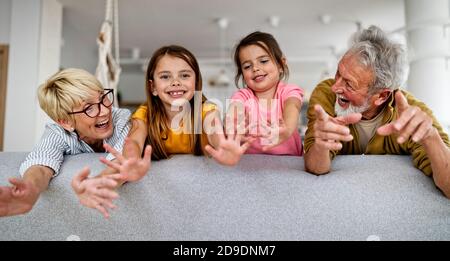 Grandchildren having fun, playing with grandparents at home Stock Photo