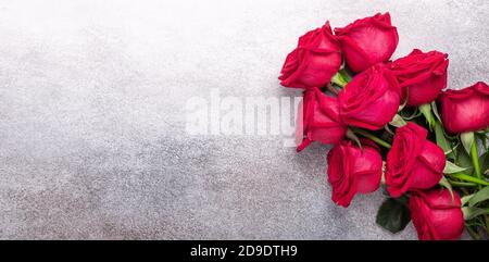 Horizontal banner with bouquet of red roses on stone background. Valentines day greeting card - Image