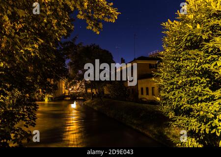 View on Cagnan river at night with a bridge and beautiful blue sky with stars in the background Treviso Italy Stock Photo