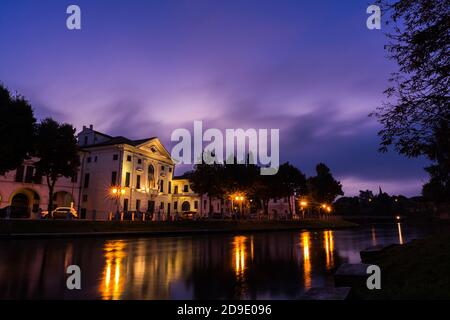 Picturesque view on the Sile river in the city center with a stunning purple sky and lights reflections on the water at night Treviso Italy Stock Photo