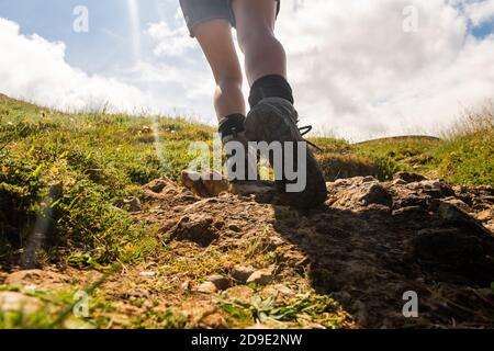 Portrait from behind woman walking uphill with hiking boots Stock Photo