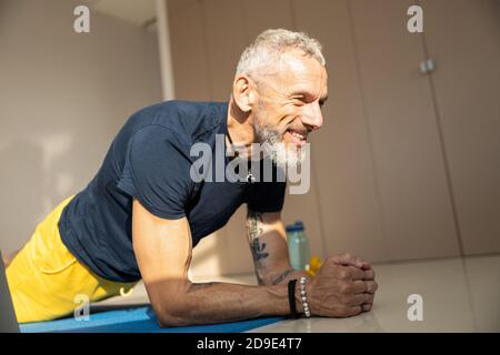 Athletic male doing a plank on a blue cover Stock Photo