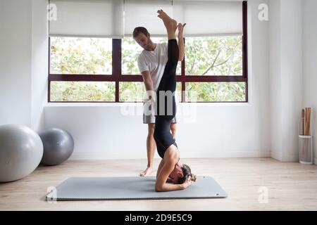 Beginner yogi and his coach practicing yoga Stock Photo