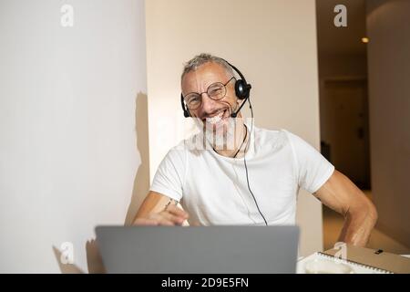 Male having a video talk and grinning widely Stock Photo