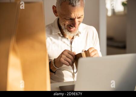 Excited man opening his present in a package Stock Photo