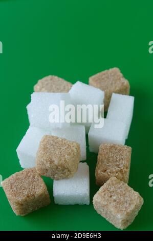 Cube of white and brown sugar on a green background. Green screen background. Stock Photo