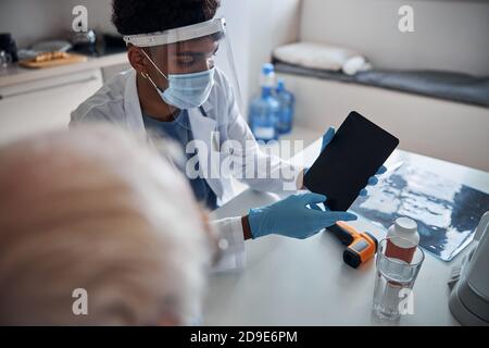 Doctor showing a portable computer to a senior man Stock Photo