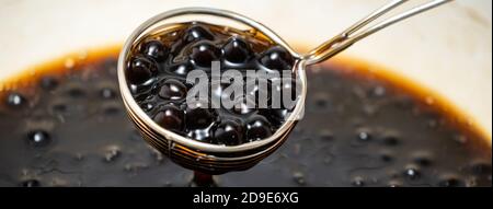 Cooking, boiling brown sugar flavored tapioca pearl balls, ingredient of bubble tea, preparing food and drink, close up, recipe cookbook steps design Stock Photo