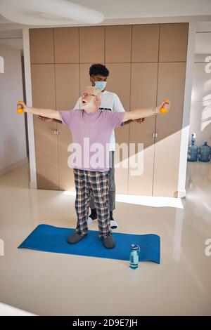 Pensioner working out with his fitness instructor Stock Photo