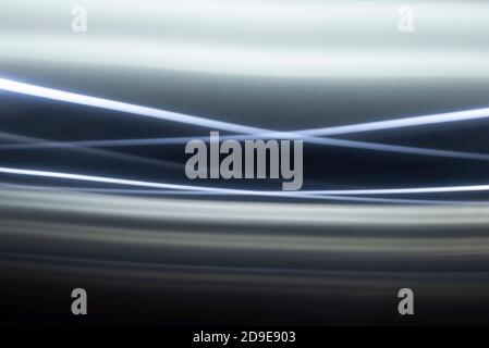 Gray metallic background with blurred reflections of light cross beams. High-tech style. Stock Photo