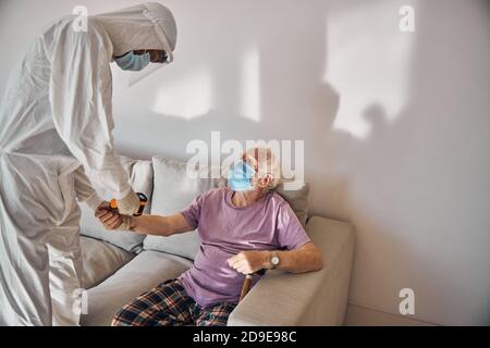 Healthcare professional using an infrared thermometer on the patient Stock Photo