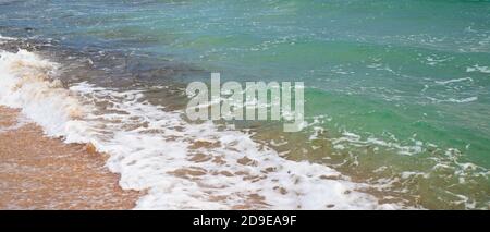 Natural background of the turquoise sea of ​​sea foam and light sand. Copy space for text. Banner. Stock Photo