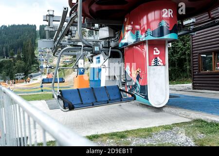 Bukovel, Ukraine - July 2020: Empty ski lift or chairlift at Ukrainian resort Bukovel in summertime. Less local tourists during pandemic isolation. Stock Photo