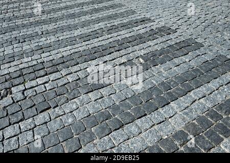 Cobblestone street in an old medieval city. Paved boulevard or avenue made of stones. Urban footpath tile mosaic from rock material. Cobbled pavement Stock Photo