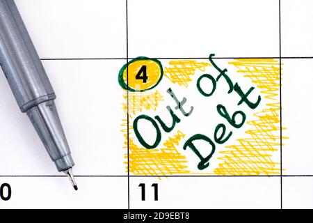 Reminder Out of Debt in calendar with pen. Close-up Stock Photo