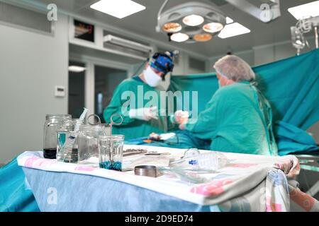 Surgeon and his assistant performing cosmetic surgery on nose in hospital operating room. Nose reshaping, augmentation. Rhinoplasty. Stock Photo