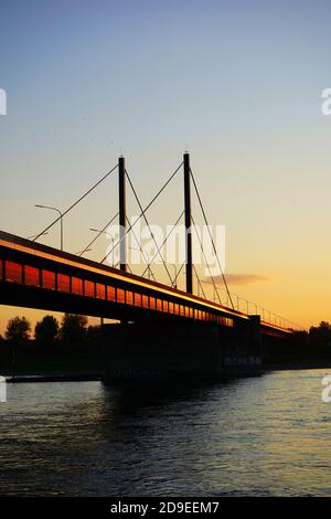 Theodor-Heuss-Brücke, the first cable-stayed bridge in Germany, with reflection of the setting sun. Stock Photo