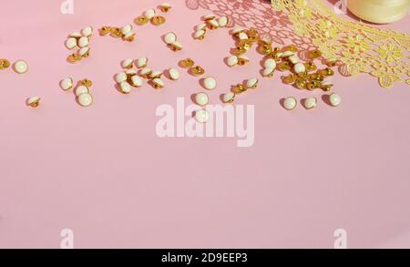 Small buttons on a pink background. Items for needlework. For sewing clothes. Sewing. Free space for text. Stock Photo