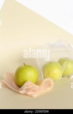 Apples in reusable eco friendly transparent bags on bright background with copy space. Stock Photo