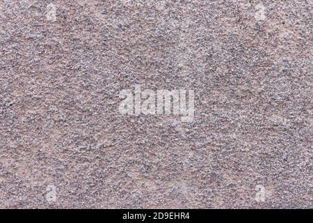 The surface of a rough uneven wall, plastered with fine marble chips. Stock Photo