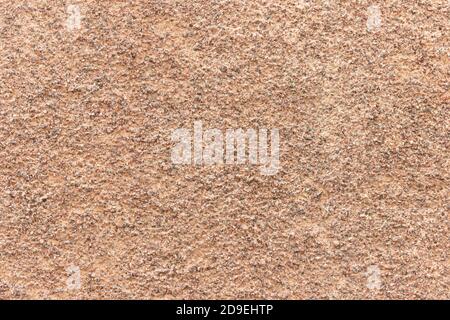 The surface of a rough uneven wall, plastered with fine marble chips. Stock Photo