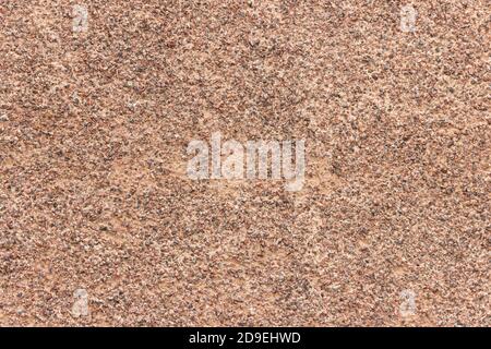 The surface of a rough uneven wall, plastered with fine marble chips. Stock Photo