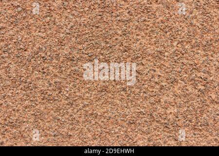 The surface of a rough uneven wall, plastered with fine marble chips. Stock Photo