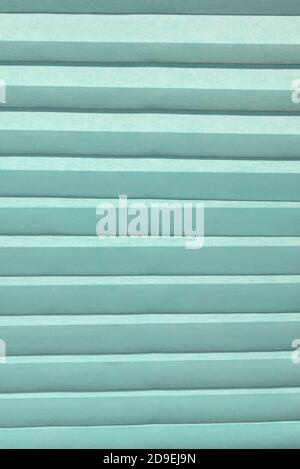 Background of blue pleated horizontal. Vertical format. The texture of the nonwoven fabric in the crease. Jalousie. Stock Photo