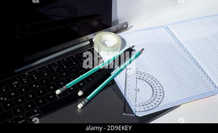 Stationery on laptop keyboard. Modern opportunities for work and study. Stock Photo
