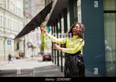 Portrait of young beautiful african american woman holding black umbrella. Stock Photo