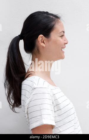 Close up profile portrait smiling young asian woman by white background Stock Photo