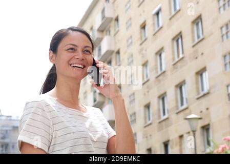 Close up portrait young asian woman talking with mobile phone in city Stock Photo