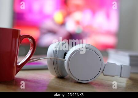 white headphones with music video on tv screen in background Stock Photo