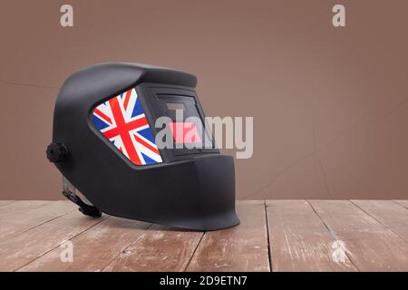 Industrial tool - United Kingdom of Great Britain and Northern Ireland flag Mask Welding machine on a wooden and brawn wall background Stock Photo