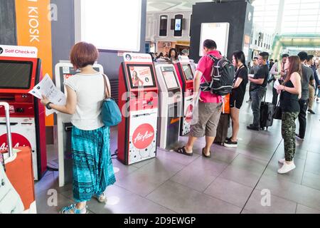 KUALA LUMPUR, MALAYSIA, JUNE 18, 2018: Passenger using convenient self check-in kiosk machine at KL International Airport facility to check in their Stock Photo