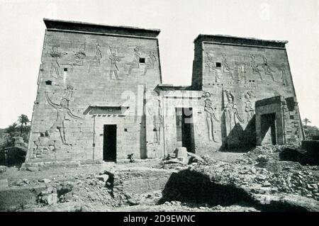 This photo shows the south front of temple of Isis at Philae - before the building of the Aswan Dam. Construction on the temple began around 280 B.C. Built during the reign of Ptolemy II (Egypt’s Greco-Roman Period), the Temple of Isis at Philae is dedicated to Isis, Osiris, and Horus. The temple walls contain Stock Photo