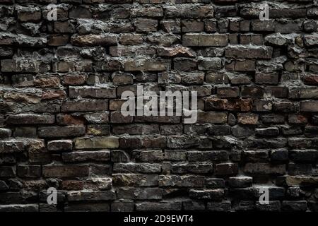 Urban black brick wall texture old masonry background. Gloomy background, black brick wall of dark stone texture Stock Photo