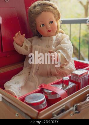 Vintage doll in a vintage suitcase. Stock Photo