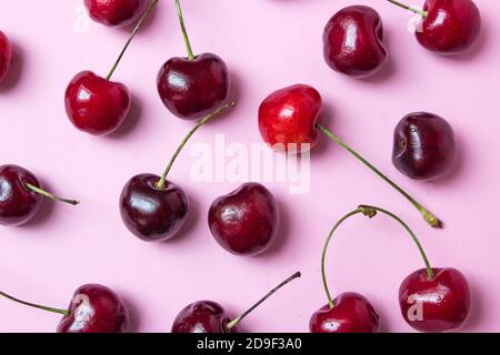 Red berries of tasty juicy cherry lie on pink. Photo flat lay on pink background Stock Photo