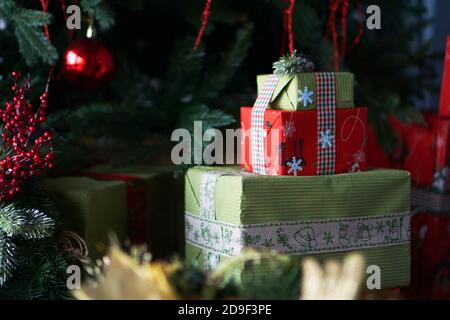Beautiful Christmas green and red gift boxes under the Christmas tree. Holiday time. Stock Photo