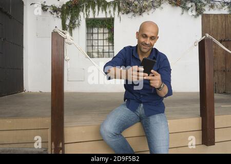 Caucasian man looking at his phone and smiling Stock Photo