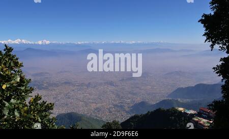 Beautiful panorama view of Kathmandu valley, Nepal with visible smog above the city, the majestic Himalaya mountain range and a luxury holiday resort. Stock Photo