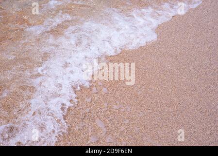 Texture of sea foam on pink sand. Backgrounds. Natural frame. Copy space for text. Stock Photo