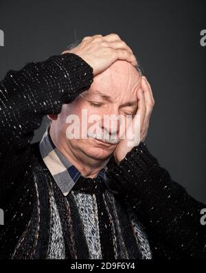 Elderly man suffering from a headache and toothache Stock Photo