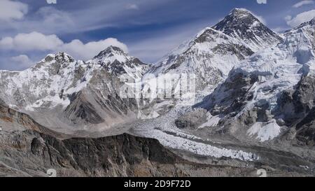 Spectacular panorama view of mighty Mount Everest (summit: 8,848 m) surrounded by snow-capped mountains and famous Khumbu ice fall below in Nepal. Stock Photo