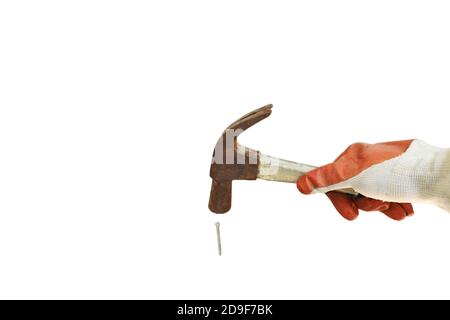 hand wearing safety glove holding old iron hammer smashing on nail in white background Stock Photo