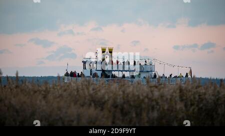 Zingst, Germany. 22nd Oct, 2020. The paddle steamer 'Baltic Star' brings tourists over the Prerow Current to the vicinity of the cranes' resting and sleeping places. More than 50,000 cranes fly in from the Baltic States every year in autumn and rest on the Fischland-Darß-Zingst peninsula, the mainland of Western Pomerania and the island of Rügen before continuing their flight to the warm south. Credit: Stephan Schulz/dpa-Zentralbild/ZB/dpa/Alamy Live News Stock Photo