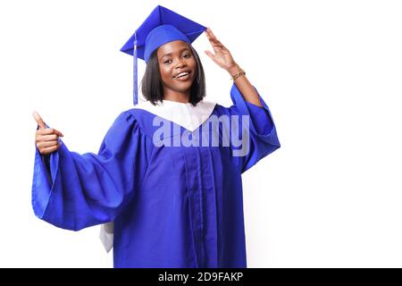African-American beautiful woman in a blue robe and hat, on a white isolated background smiles and shows thumbs up Stock Photo